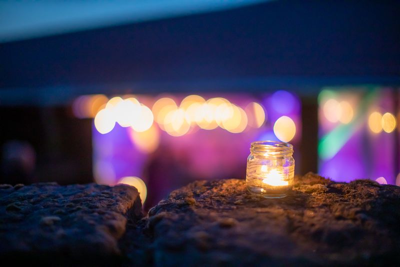 Kerze vor den Lichtern der Feier